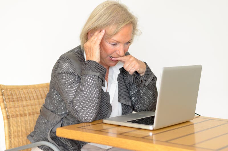Aktive blonde ältere Frau mit dem Abendtoilettesitzen durchdacht lizenzfreie stockbilder Aktive blonde ältere Frau mit dem Abendtoilettesitzen durchdacht lizenzfreie stockbilder