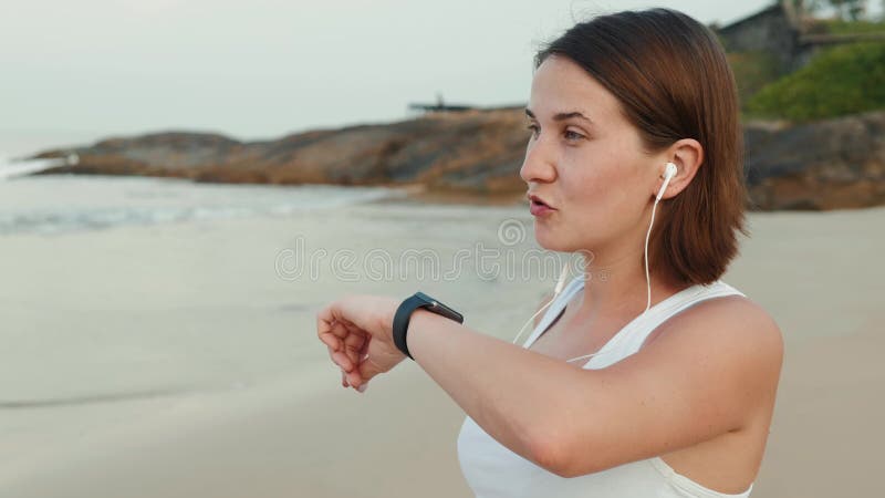 Aktive Lebensstilfrau, die Technologie smartwatch intelligente Uhr schaut Nahaufnahmemakroabschluß herauf Armstrand-Touch Screen