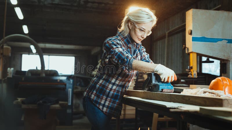 Aktive mittlere Greisin wählt Holz in der Werkstatt vor Konzept der Berufs- orientierten motivierten modernen Frau Gleichberechti