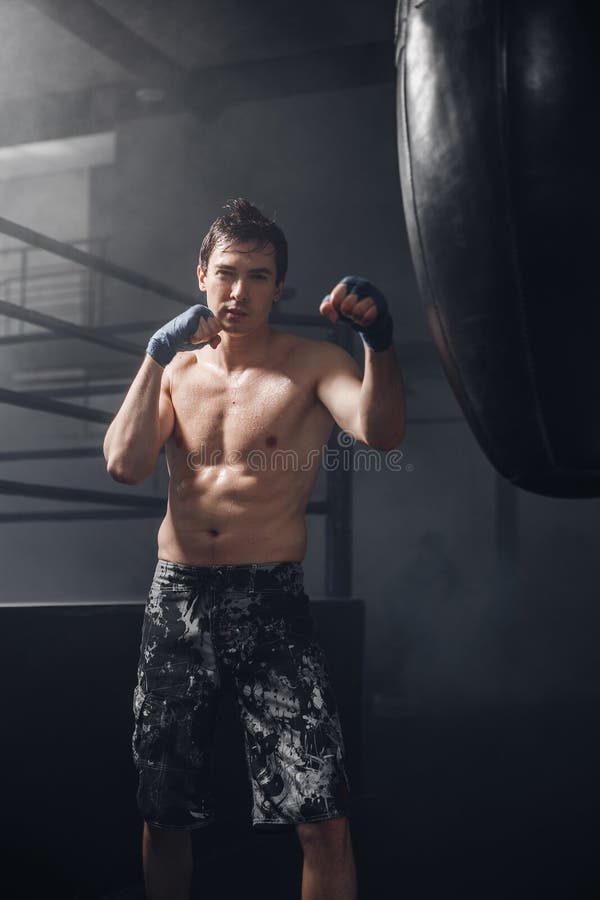 Aktiver Mann mit Verpacken wickelt Trainingsdurchschlag für Sandsack ein lizenzfreie stockfotos Aktiver Mann mit Verpacken wickelt Trainingsdurchschlag für Sandsack ein lizenzfreie stockfotos