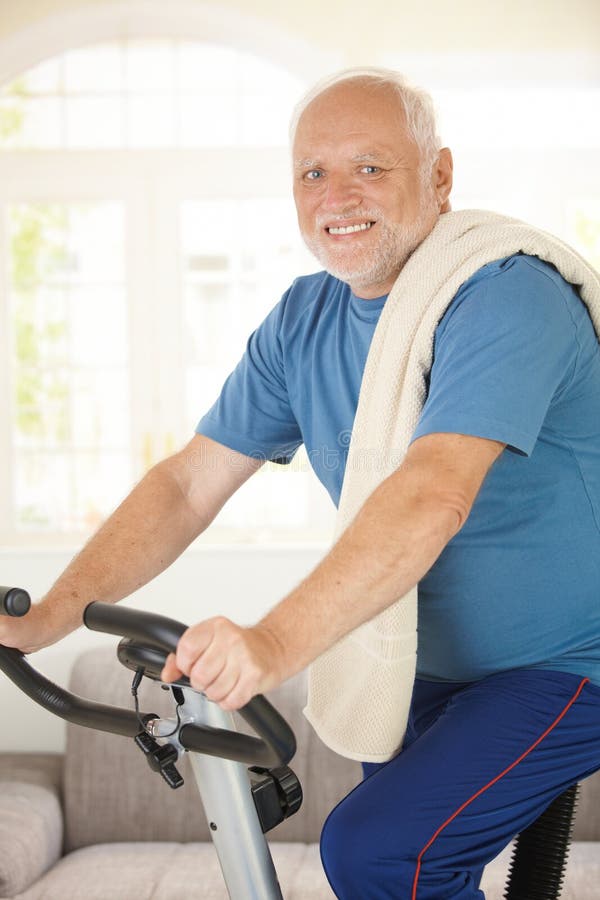 Aktiver Älterer, der Übungsfahrrad verwendet lizenzfreies stockfoto Aktiver Älterer, der Übungsfahrrad verwendet lizenzfreies stockfoto