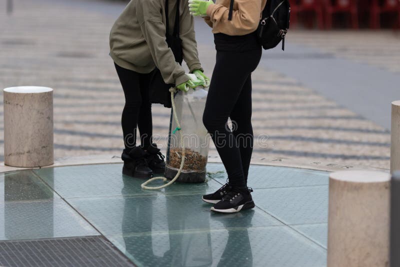 Activists collect cigarette bulls dropped on the street. Mid shot. Activists collect cigarette bulls dropped on the street. Mid shot