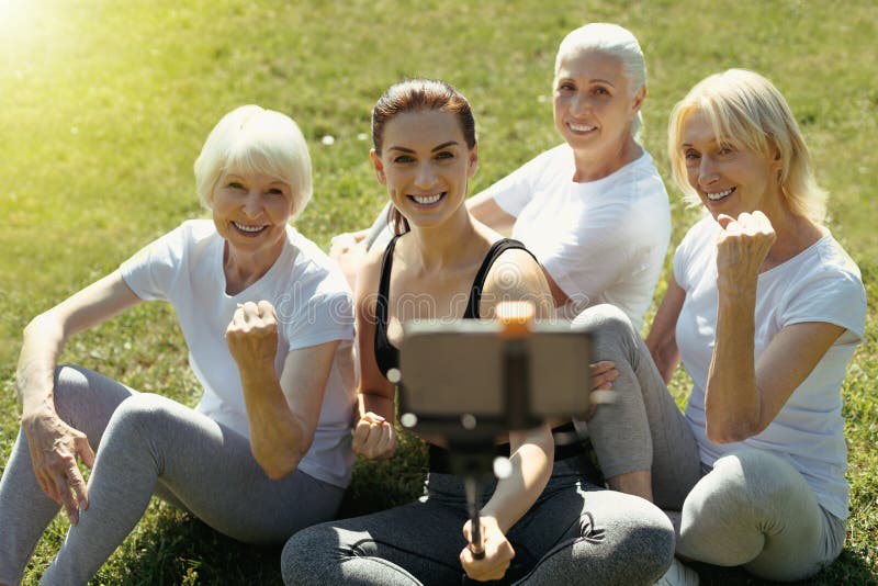 Aktywne starsze damy pozuje dla selfie z trenerem zdjęcia stock Aktywne starsze damy pozuje dla selfie z trenerem zdjęcia stock