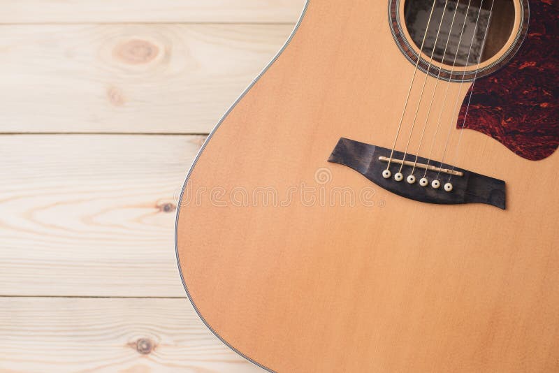 Akustikgitarre, die gegen einen hölzernen Hintergrund stillsteht stockfotografie Akustikgitarre, die gegen einen hölzernen Hintergrund stillsteht stockfotografie
