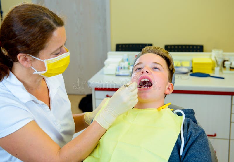 Al dentista de sexo femenino trata al muchacho imagenes de archivo Al dentista de sexo femenino trata al muchacho imagenes de archivo