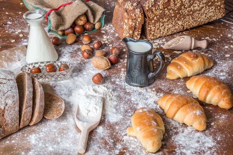 Al forno, alla natura morta con i mini croissant, al pane, al latte, ai dadi ed alla farina immagini stock Al forno, alla natura morta con i mini croissant, al pane, al latte, ai dadi ed alla farina immagini stock
