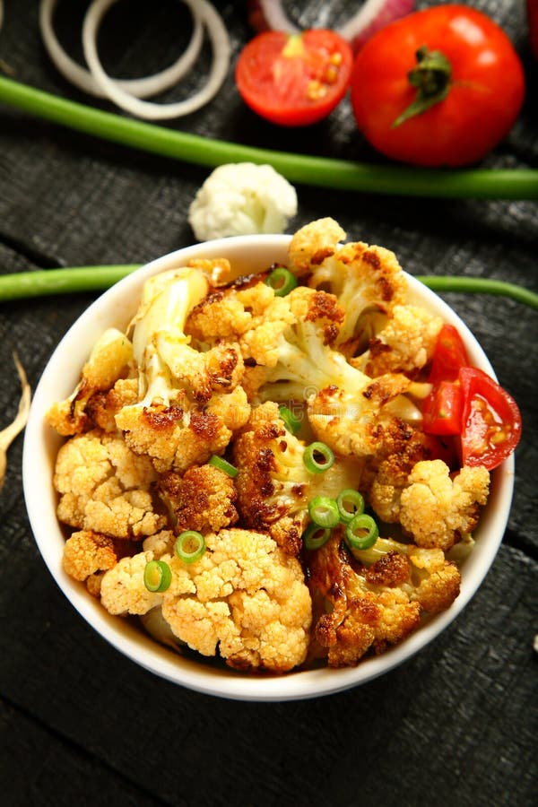 Al forno vista-delizioso superiore del cavolfiore dell'alimento del vegano servito in ciotola fotografia stock Al forno vista-delizioso superiore del cavolfiore dell'alimento del vegano servito in ciotola fotografia stock