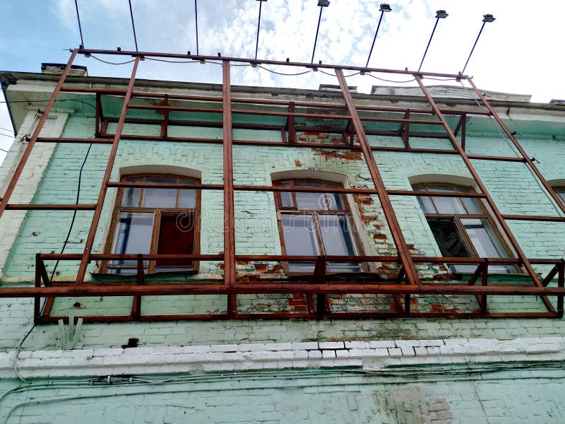 Al piano superiore, il vecchio edificio in mattoni è dipinto di vernice verde e morbida I telai delle finestre sono di legno Cost fotografie stock libere da diritti Al piano superiore, il vecchio edificio in mattoni è dipinto di vernice verde e morbida I telai delle finestre sono di legno Cost fotografie stock libere da diritti