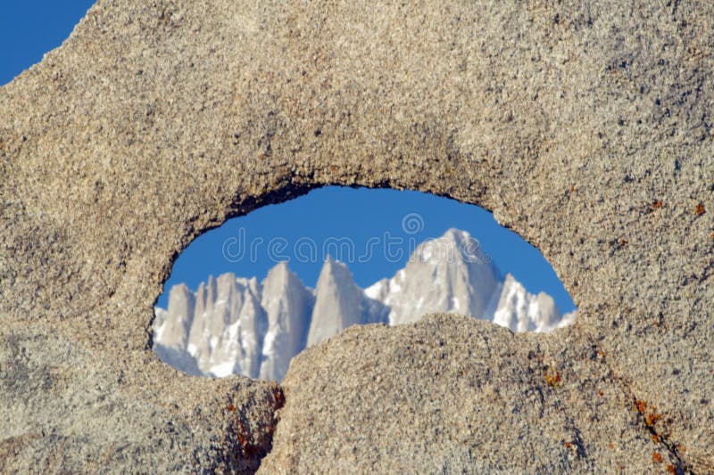 The Alabama Hills hole in rock framing Mount Whitney and the snowy Sierra Mountains at sunrise near Lone Pine, CA