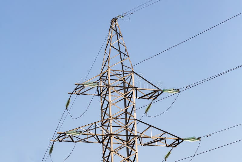 Alambres de la línea eléctrica contra la pieza del cielo azul de la torre del metal imagen de archivo libre de regalías Alambres de la línea eléctrica contra la pieza del cielo azul de la torre del metal imagen de archivo libre de regalías