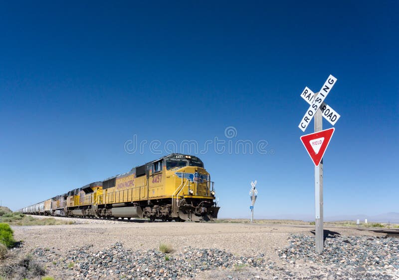 Alamogordo, NM / United States - July 10, 2016: Union Pacific freight train crosses a railroad crossing in the New Mexico desert o