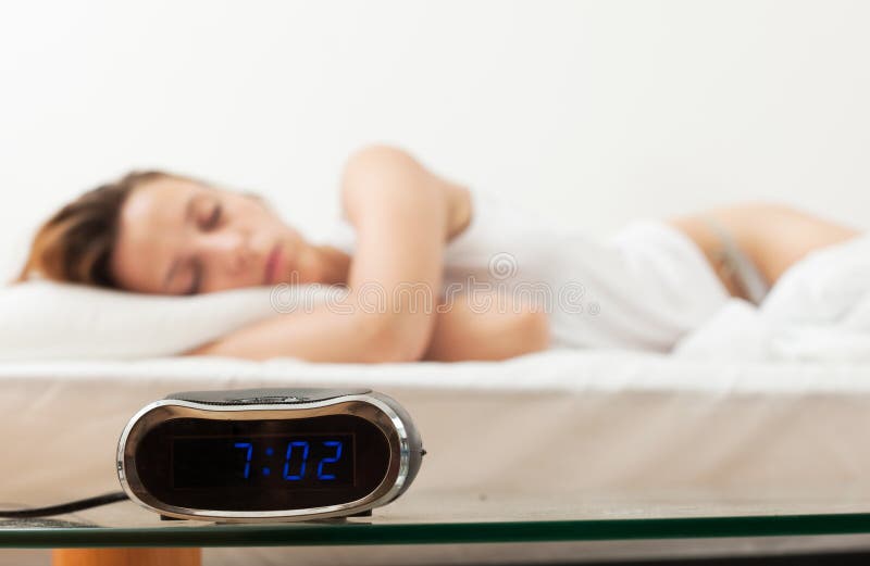 Alarm Clock by the Bad of Sleeping Woman Stock Photo Image of people