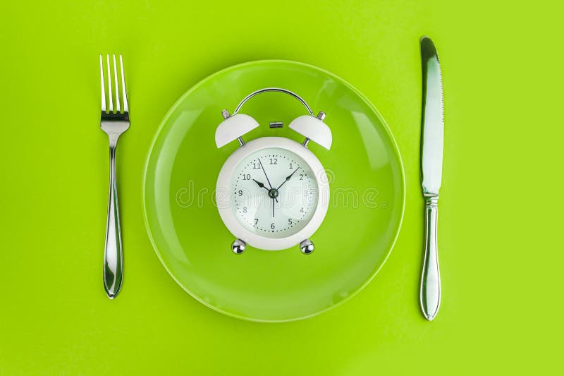 Alarm Clock with Fork and Knife on the Table. Time To Eat, Breakfast