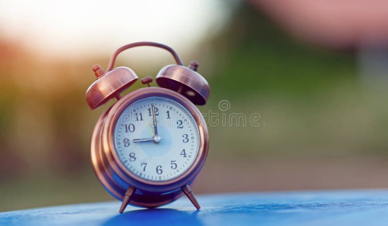 Alarm clock picture placed on a blue table, green background Punctual concept With copy space