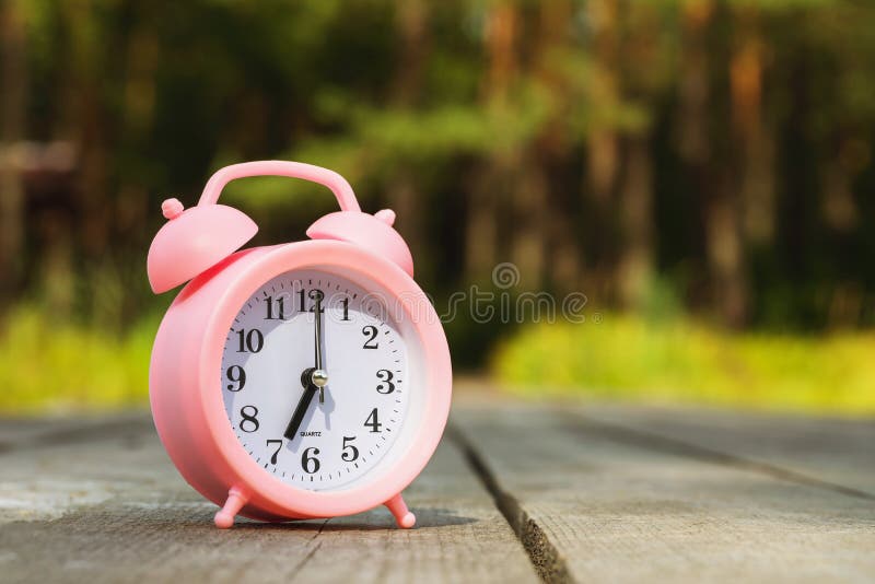 Alarm Clock on Wooden Bridge on Nature Background with Copy Space Stock
