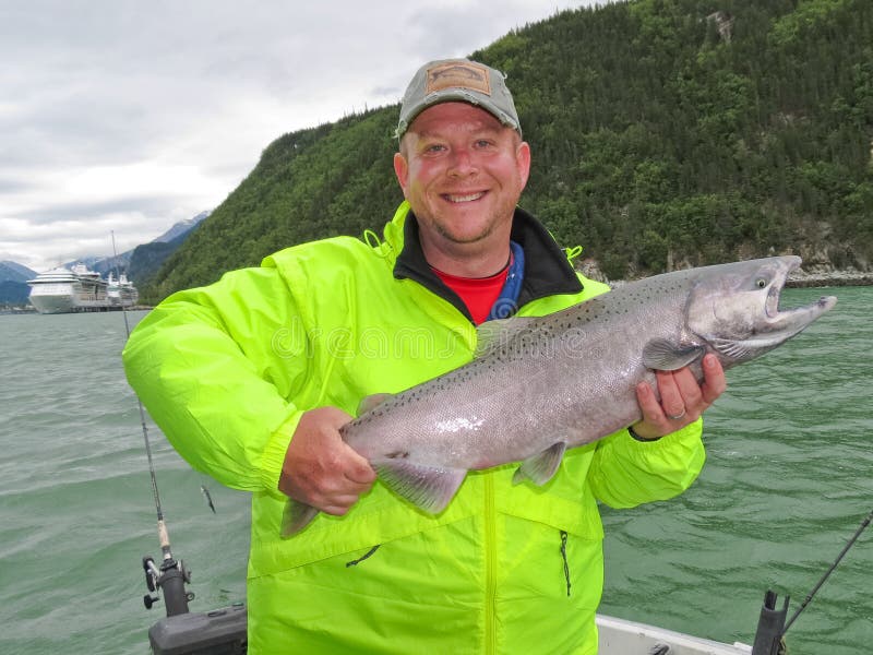 Alaska - hombre feliz que detiene al rey salmón foto de archivo libre de regalías