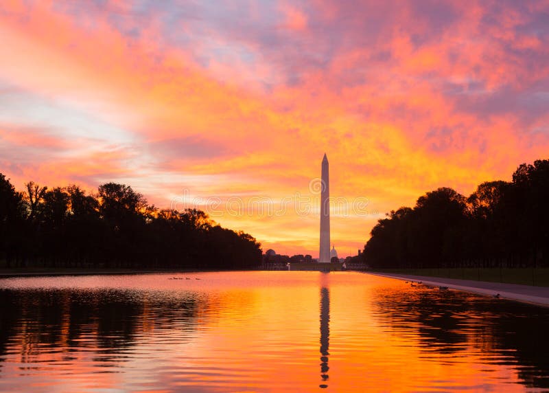 Bright red and orange sunrise at dawn reflects Washington Monument in new reflecting pool by Lincoln Memorial. Bright red and orange sunrise at dawn reflects Washington Monument in new reflecting pool by Lincoln Memorial