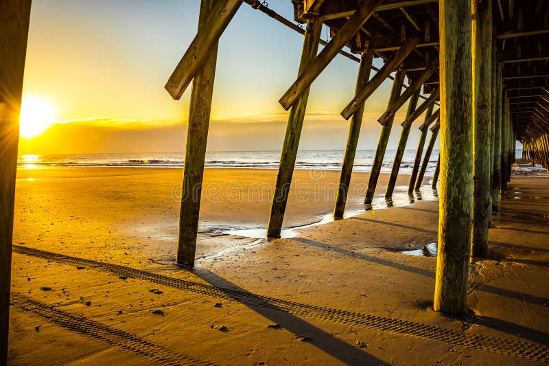 Alba sotto Myrtle Beach Fishing Pier fotografia stock libera da diritti Alba sotto Myrtle Beach Fishing Pier fotografia stock libera da diritti