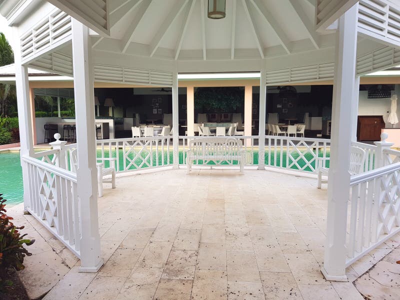 ALBANY, NASSAU LES BAHAMAS - 21 JUILLET 2018 Banc blanc, belvédère dans une piscine dans le jardin d'un lieu de villégiature luxu photo libre de droits ALBANY, NASSAU LES BAHAMAS - 21 JUILLET 2018 Banc blanc, belvédère dans une piscine dans le jardin d'un lieu de villégiature luxu photo libre de droits