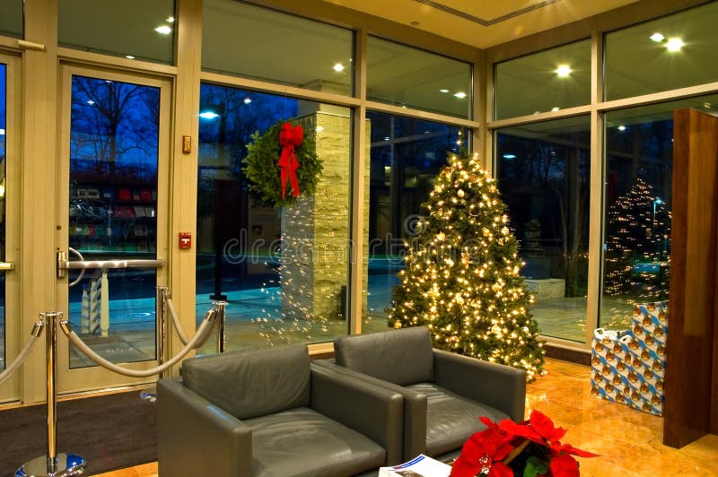 Waiting area and lobby of modern office building decorated for the holidays with poinsettias, wreath and Christmas tree. Waiting area and lobby of modern office building decorated for the holidays with poinsettias, wreath and Christmas tree.