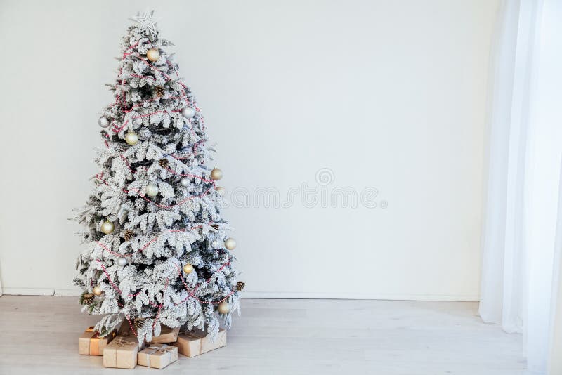 Christmas snowy Christmas tree with presents in a white room in winter 1. Christmas snowy Christmas tree with presents in a white room in winter 1