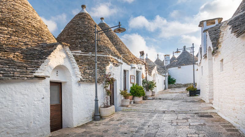 Alberobello - the land of trulli houses on the UNESCO list. Picturesque white houses with stone roofs against the blue sky. Cottages a tourist attraction in royalty free stock photos Alberobello - the land of trulli houses on the UNESCO list. Picturesque white houses with stone roofs against the blue sky. Cottages a tourist attraction in royalty free stock photos
