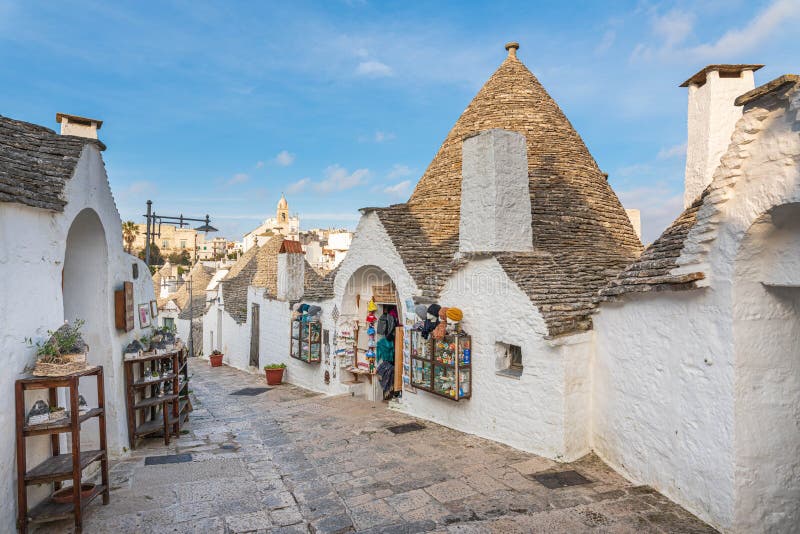 Alberobello - the land of trulli houses on the UNESCO list. Picturesque white houses with stone roofs against the blue sky. Cottages a tourist attraction in royalty free stock photo Alberobello - the land of trulli houses on the UNESCO list. Picturesque white houses with stone roofs against the blue sky. Cottages a tourist attraction in royalty free stock photo