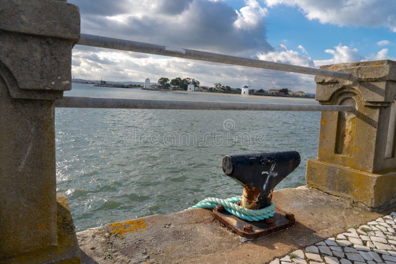 3 alburrica windmills in Barreiro with old wall in the foreground 2 horizontal iron bars and boat mooring support