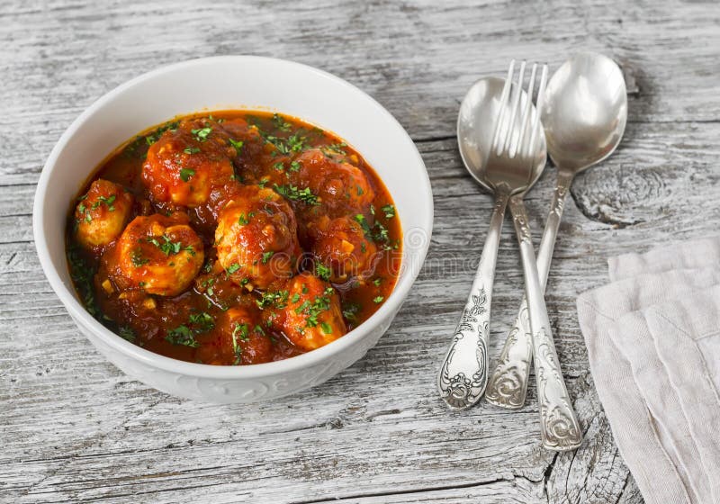 Albóndigas del pollo con la salsa de tomate en un cuenco blanco en superficie de madera brillante fotos de archivo libres de regalías Albóndigas del pollo con la salsa de tomate en un cuenco blanco en superficie de madera brillante fotos de archivo libres de regalías