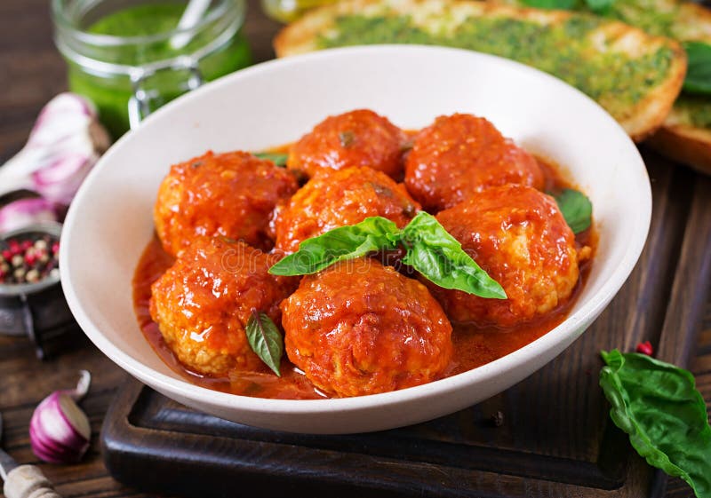 Albóndigas en salsa y tostada de tomate con pesto de la albahaca cena foto de archivo Albóndigas en salsa y tostada de tomate con pesto de la albahaca cena foto de archivo