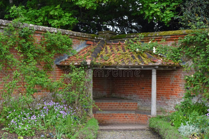 Alcoba cubierta Seat en jardín emparedado en la abadía de Mottisfont, Hampshire, Inglaterra