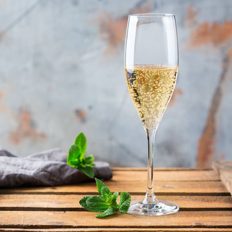 Food and drink, holidays party concept. Cold fresh alcohol beverage champagne sparkling white wine with bubbles in a flute glass on a wooden table. Copy space background. Food and drink, holidays party concept. Cold fresh alcohol beverage champagne sparkling white wine with bubbles in a flute glass on a wooden table. Copy space background