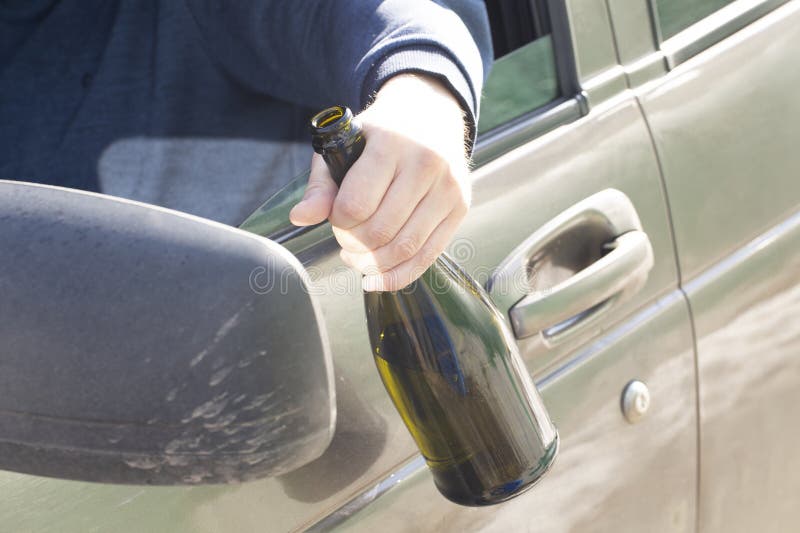 Alcohol while Driving a Car. a Driver Who Drinks Alcohol at the Wheel