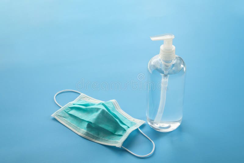 Alcohol Hand Sanitizer Gel Bottle With Surgical Face Mask On Blue