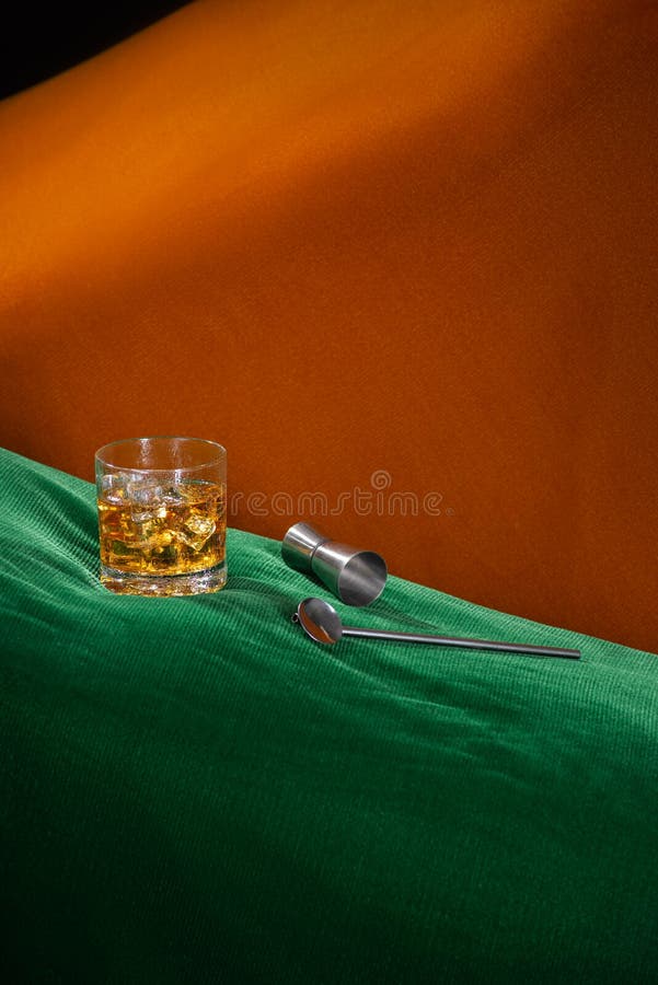 Alcoholic Drink with Ice on a Green and Orange Abstract Space with