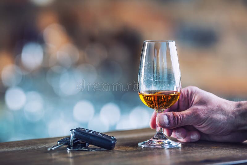 Alcoholism. Cup cognac or brandy hand man the keys to the car an royalty free stock photo Alcoholism. Cup cognac or brandy hand man the keys to the car an royalty free stock photo