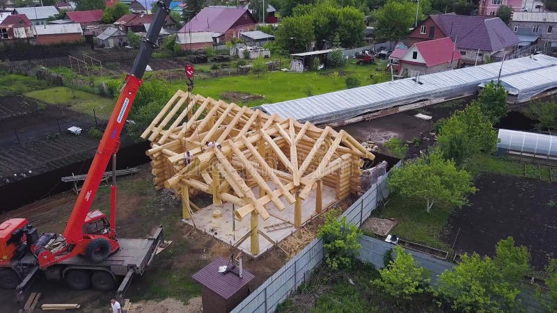 Aldeia com casa de madeira em construção Clipe Visão superior do processo de construção de uma casa de madeira sobre o fundo de