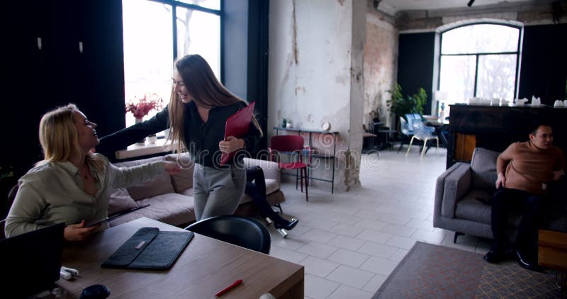 Alegre feliz feliz joven exitosa mujer de negocios rubia saludo y abrazo a colegas en la ocupada y moderna oficina cámara lenta. almacen de metraje de vídeo