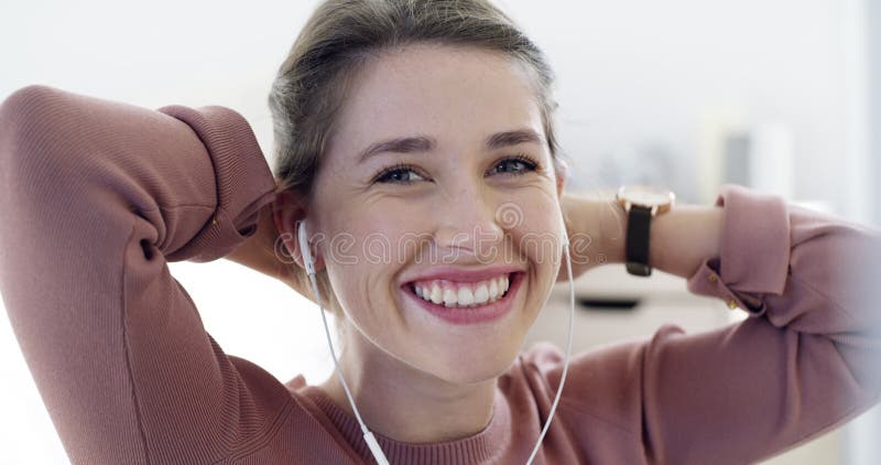 Alegre feliz y sonriente mientras escuchaba música a través de auriculares mientras se ataba el pelo. retrato de una hermosa metrajes