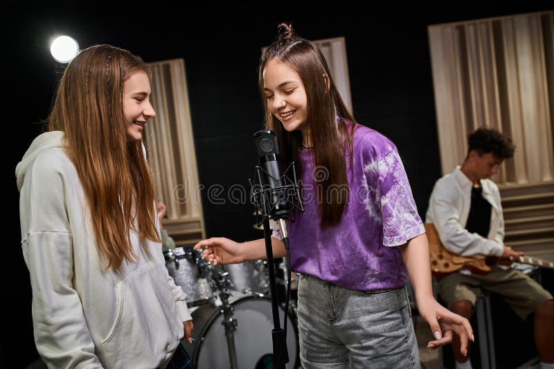 joyous adorable teenage girls singing happily while their friend playing guitar, musical group, stock photo. joyous adorable teenage girls singing happily while their friend playing guitar, musical group, stock photo