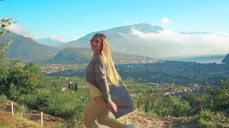 Alegre y alegre mujer joven turista bailando saltando pelo largo volando alegremente lanzas. niñas con las manos en hilatura levan almacen de metraje de vídeo