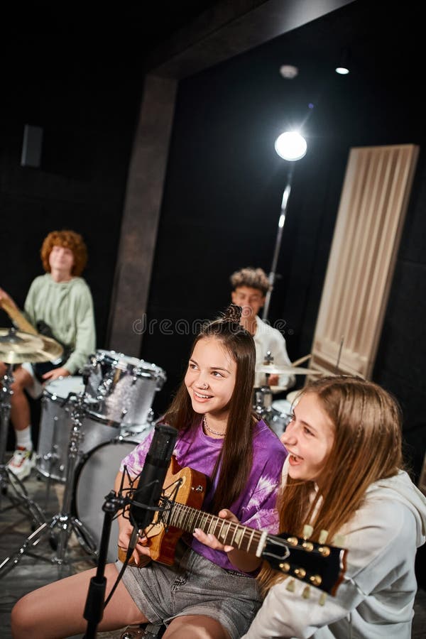 cheerful pretty teenagers singing and playing various instruments in studio, musical group, stock photo. cheerful pretty teenagers singing and playing various instruments in studio, musical group, stock photo