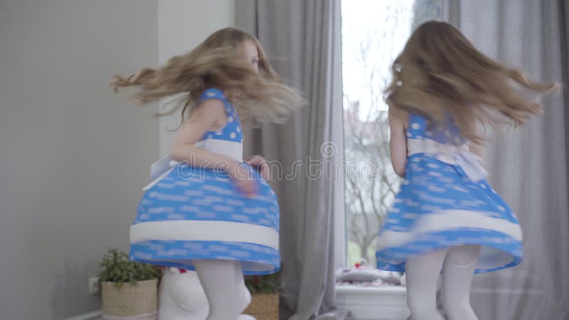 Alegres chicas caucásicas con elegantes vestidos de puntos azules saltando y dando vueltas en casa Retrato de alegre feliz almacen de video