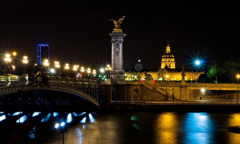 The Alexander III bridge and the dome of the Invalides at night stock image The Alexander III bridge and the dome of the Invalides at night stock image
