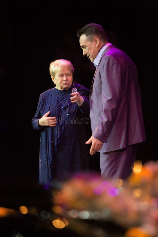 MOSCOW - FEB 26: Alexandra Pakhmutova on stage with Artist of Russia Renat Ibragimov present a new song in the Moscow International House of Music on February 26, 2013 in Moscow, Russia. Alexandra Pakhmutova outstanding Soviet and Russian composer, author of more than 400 songs. MOSCOW - FEB 26: Alexandra Pakhmutova on stage with Artist of Russia Renat Ibragimov present a new song in the Moscow International House of Music on February 26, 2013 in Moscow, Russia. Alexandra Pakhmutova outstanding Soviet and Russian composer, author of more than 400 songs.