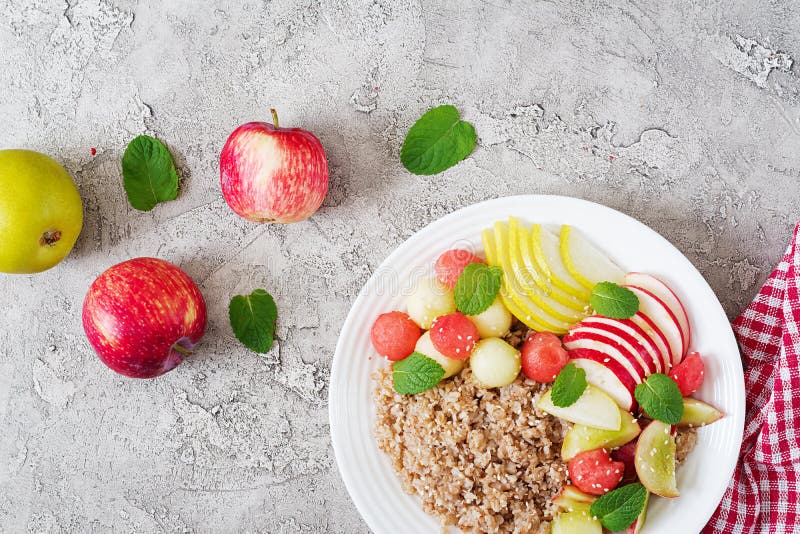 Alforfón o gachas de avena con el melón, la sandía, la manzana y la pera frescos foto de archivo Alforfón o gachas de avena con el melón, la sandía, la manzana y la pera frescos foto de archivo