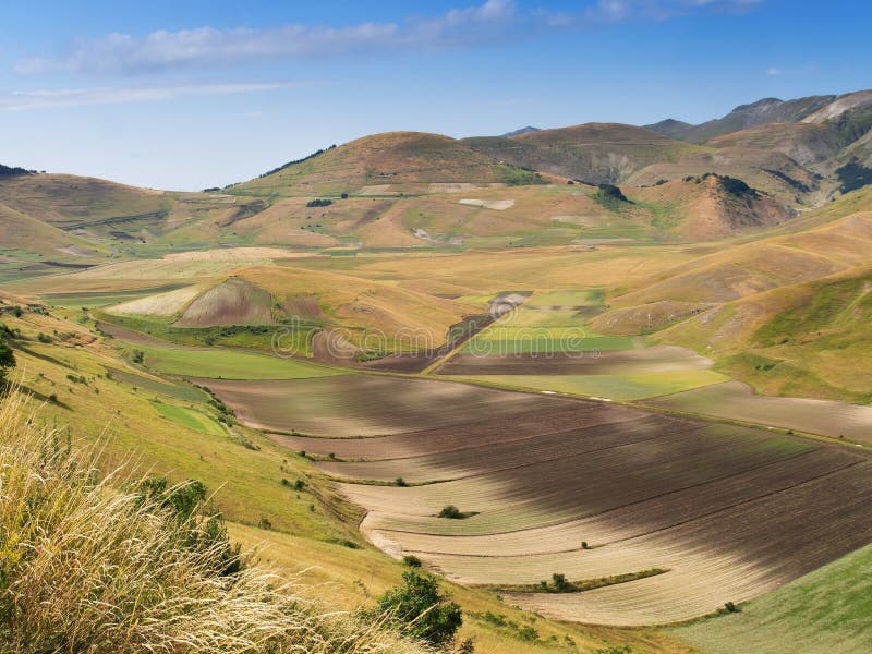 Algemene mening van de vallei, Castelluccio Di Norcia, in Umbrië, Italië Gebieden en heuvels, met schaduwen van het overgaan van