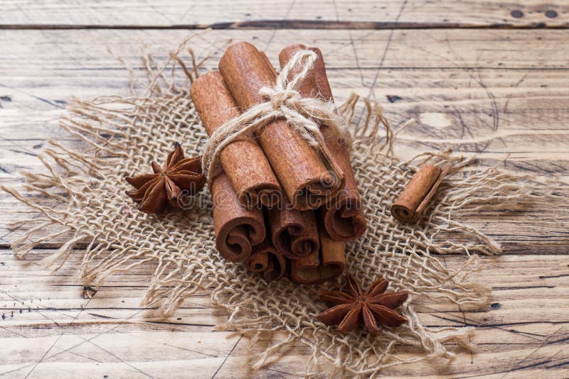 Alguns bastões de canela amarrados com fios e anis em fundo de madeira. Copiar espaço. Foco seletivo imagem de stock Alguns bastões de canela amarrados com fios e anis em fundo de madeira. Copiar espaço. Foco seletivo imagem de stock