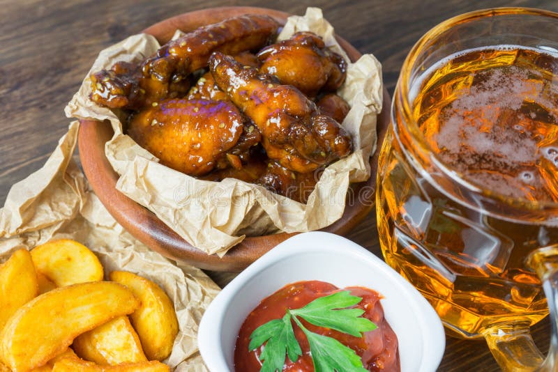 Download Ali Di Pollo Con Salsa Fragrante E Pungente Con I Semi Di Sesamo Un Vetro Di Birra Fredda Fresca E Delle Patate Fritte Con Il Pom Fotografia Stock - Immagine di alcool, barbecue: 117979422
