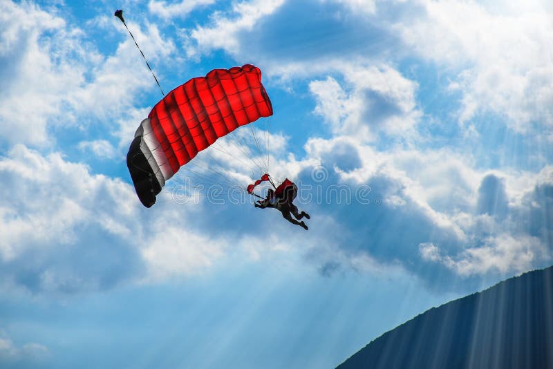 Aliante con il volo rosso del paracadute nel cielo blu fotografie stock Aliante con il volo rosso del paracadute nel cielo blu fotografie stock